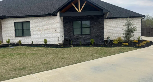 Modern house with fresh dark mulch installation in landscape beds with clean edges
